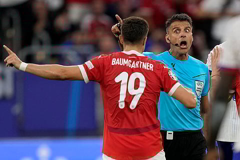 Referee Jesus Gil Manzano talks to Christoph Baumgartner